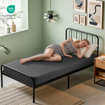 a woman is lying on the waterproof prismatic print noiseless mattress protector, gray