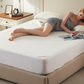 a woman lying down on the soft prismatic print mattress protector